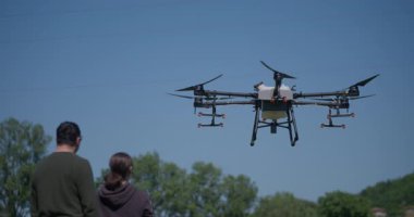 Bir tarımsal dron, akıllı tarım, hassas tarım ve sürdürülebilir büyüme ve verimli ürün yönetimi için yenilikçi teknoloji sergilenen manzaralı bir dağ vadisinde sıra sıra ekinleri izler.