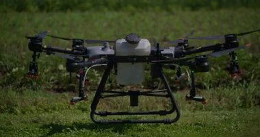 Kırsal ortamlardaki gelişmiş tarım teknolojisi ve hassas tarım tekniklerini vurgulayarak, ekin izleme veya spreyleme görevi sırasında ekili bir tarla üzerinde uçan hava aracı..