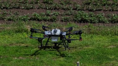 Kırsal ortamlardaki gelişmiş tarım teknolojisi ve hassas tarım tekniklerini vurgulayarak, ekin izleme veya spreyleme görevi sırasında ekili bir tarla üzerinde uçan hava aracı..