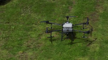 Kırsal ortamlardaki gelişmiş tarım teknolojisi ve hassas tarım tekniklerini vurgulayarak, ekin izleme veya spreyleme görevi sırasında ekili bir tarla üzerinde uçan hava aracı..