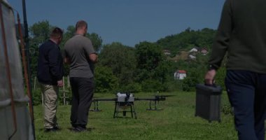 Yenilikçi bir çiftçi, günbatımında bir tarlanın ortasında dikilirken, tarım arazilerini modern akıllı tarım uygulamalarının bir parçası olarak incelemek ve tarlaları izlemek için hava teknolojisini kullanır..