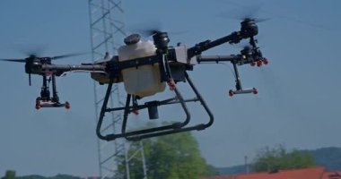 Kırsal ortamlardaki gelişmiş tarım teknolojisi ve hassas tarım tekniklerini vurgulayarak, ekin izleme veya spreyleme görevi sırasında ekili bir tarla üzerinde uçan hava aracı..