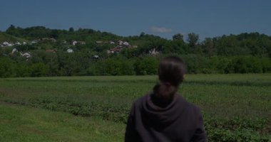 Yenilikçi bir dişi çiftçi, günbatımında bir tarlanın ortasında dikilirken, tarım arazilerini modern akıllı tarım uygulamalarının bir parçası olarak incelemek ve izlemek için hava teknolojisini kullanır..