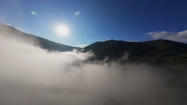 Güneşin doğuşunda yemyeşil bir vadinin hava manzarası sisli tepeler, orman ağaçları ve yumuşak sabah ışığı. Seyahat, ekolojik maceralar ve manzaralı kaçışlar için mükemmel güzel, sinematik bir manzara.