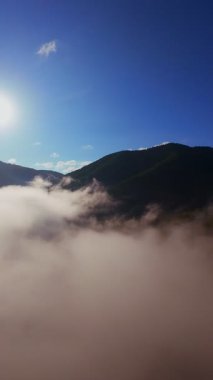Güneşin doğuşuyla birlikte yemyeşil bir vadinin hava dikey videosu sisli tepeler, orman ağaçları ve yumuşak sabah ışığı. Seyahat, ekolojik maceralar ve manzaralı kaçışlar için mükemmel güzel, sinematik bir manzara.