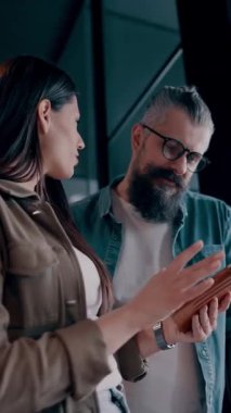 Yaratıcı milenyumlar, sıradan iş adamları, küçük işletme sahipleri, sosyal medya stratejisi ve marka geliştirme üzerinde çalışan modern, açık bir ofis ortamında dijital tabletle