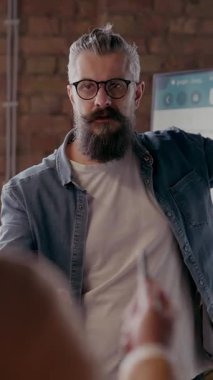 Moden ofis alanı, iş dünyasından profesyonellerden oluşan bir ekip canlı tartışmalara girişiyor ve stratejik fikirleri paylaşıyor, modern kurumsal açık alanların merkezinde işbirliği ve yenilik sergiliyor.