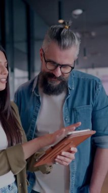 Yaratıcı milenyumlar, sıradan iş adamları, küçük işletme sahipleri, sosyal medya stratejisi ve marka geliştirme üzerinde çalışan modern, açık bir ofis ortamında dijital tabletle