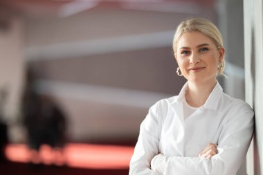 Kolları çapraz duran, modern klinik koridorunda kendine güvenen kadın doktor. Klinik koridorunda kendine güvenen kadın doktor portresi.