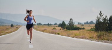 Atletik bir kadın sağlıklı bir yaşam tarzında özgürlük ve neşe bulur. Gün doğumunda güzel bir patikada koşar.. 