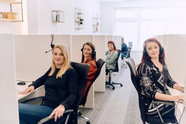 Bir çağrı merkezinde çalışan kendini adamış bir kadın ekibi, profesyonellik ve verimlilikle müşterilere telefonla yardım ve destek sağlıyor.. 