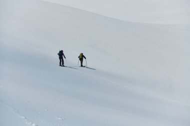 İki profesyonel kayakçı, sarsılmaz takım çalışması ve kararlılığıyla Alpler 'in karlı zirvelerine tırmanarak zirve arayışında birleştiler.. 
