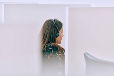 Bir kadın çağrı merkezi ajanının müşterilere özel destek ve yardım sağladığı, karşılaştıkları çeşitli sorunları çözmelerine yardımcı olduğu görülebilir.. 