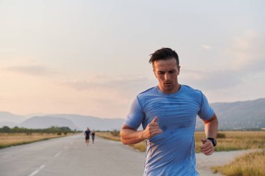 Bir grup arkadaş, güneşli bir günde dışarıda koşuşturarak sağlıklı bir yaşam tarzını sürdürüyor. Spor ve doğanın enerji verici etkilerinden keyif alıyorlar.. 