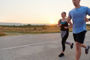 Açık havada koşan canlı bir çift atletizm ve romantizmin özünü somutlaştırıyor. Kendine güvenen adımları gelecekteki maratona ortak bir bağlılığı ve hazırlığı yansıtıyor.
