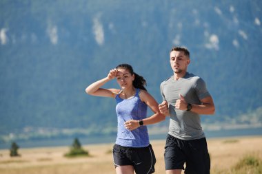Bir çift güneş lekeli bir yolda koşar, vücutları güçlü ve sağlıklıdır, birbirlerine olan sevgileri ve her adımda aşikardır.. 