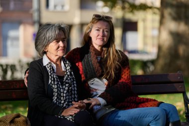 Güzel bir günde, sakin bir parkta, bir kız büyük annesini sevgiyle kucaklıyor, birlikte geçirdikleri güzel bir anı paylaşırken ona destek ve neşe sunuyor..