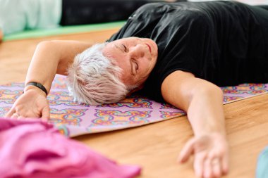 Güneşli bir ortamda, son sınıf bir kadın zarif bir şekilde yogayı gençleştirir, boyun, sırt ve bacak hareketlerine odaklanır, dinginliği ve refahı somutlaştırır.. 