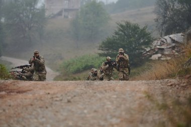 Disiplinli ve özel bir askeri birlik, kamuflajlı, stratejik devriye gezen ve yüksek bahisli bir ortamda kontrolü elinde tutan, hassasiyetlerini, birliklerini ve hazırlıklarını gösteren