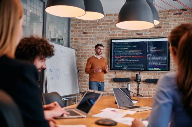 Kurumsal bir kurum kuran bir işadamı, bir toplantı düzenler, özenli ekibine tutkuyla bir iş planı sunar, işbirliği ve stratejik düşünmeyi teşvik eder.. 