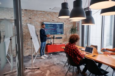 Kurumsal bir ortamda, Afrikalı-Amerikalı bir işadamı bir toplantıya liderlik eder, özenli ekibine tutkuyla bir iş planı sunar, işbirliği ve stratejik düşünmeyi teşvik eder.. 