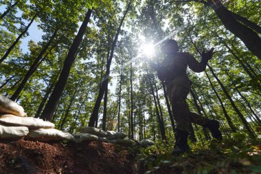 Seçkin bir asker tehlikeli ormanlık alandaki askeri engelleri aşarak özel eğitim sırasında taktiksel beceri ve çeviklik sergiliyor.. 