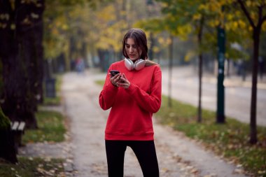 Atletik genç kadın, koşudan ve esnemeden sonra nefes alıyor ve dinleniyor. Sokakta Kadın Eğitimi ve Egzersizleri. Zayıf ve formda bir kız aktif fitness eğitiminden sonra esniyor.. 