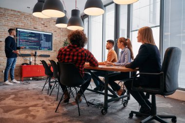 Kurumsal bir ortamda, Afrikalı-Amerikalı bir işadamı bir toplantıya liderlik eder, özenli ekibine tutkuyla bir iş planı sunar, işbirliği ve stratejik düşünmeyi teşvik eder.. 