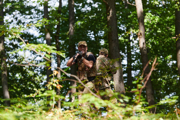 Специализированное военное антитеррористическое подразделение проводит секретную операцию в густой, опасной лесной местности, демонстрируя точность, дисциплину и стратегическую готовность.. 