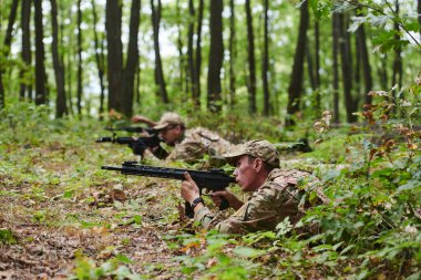 Seçkin askerler, gizli ve stratejik bir askeri göreve çıktıklarında özel teçhizatlarla kamufle edilmiş sık ormanlarda gizlice manevra yaparlar.. 