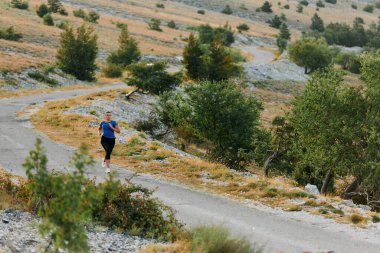 Kararlı bir bayan atlet gün doğumunda ormanda koşuyor, nefes kesici doğal güzellik ve canlı yeşillik ile çevrili.. 