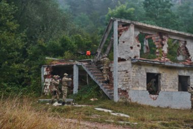 Elit askeri birim, son teknolojiyle donatılmış insansız hava aracı dahil, stratejik olarak ormanlık alanda geziniyor ve araştırıyor, hassasiyetlerini, iş birliklerini ve uzmanlıklarını gösteriyor.