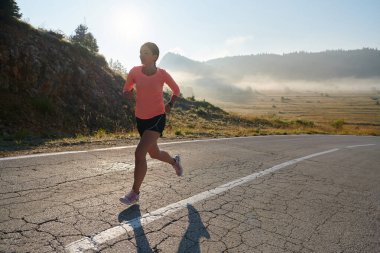Kararlı ve motive olmuş bir sporcu gün doğumuna güvenle koşuyor, sabah koşusunda kararlılığını ve gücünü özetliyor.. 