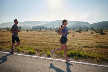 Bir çift güneş lekeli bir yolda koşar, vücutları güçlü ve sağlıklıdır, birbirlerine olan sevgileri ve her adımda aşikardır.. 