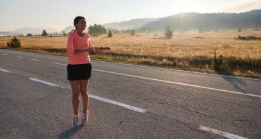 Kararlı bir atletik kadın koşudan sonra esneme hareketleri yapar, spor yolculuğuna kendini adamaya ve vücudunun esnekliğini ve esnekliğini arttırmaya çalışır.