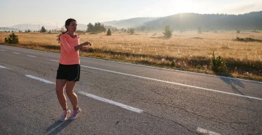  Kararlı bir atletik kadın koşudan sonra esneme hareketleri yapar, spor yolculuğuna kendini adamaya ve vücudunun esnekliğini ve esnekliğini arttırmaya çalışır.