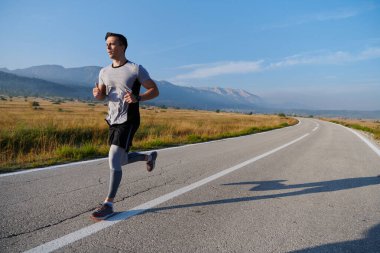 Atletik bir adam koşarken kararlılığını sergiler, sağlıklı bir yaşam tarzına ve yaklaşan maraton yarışmasına hazırlanmaya bağlıdır.
