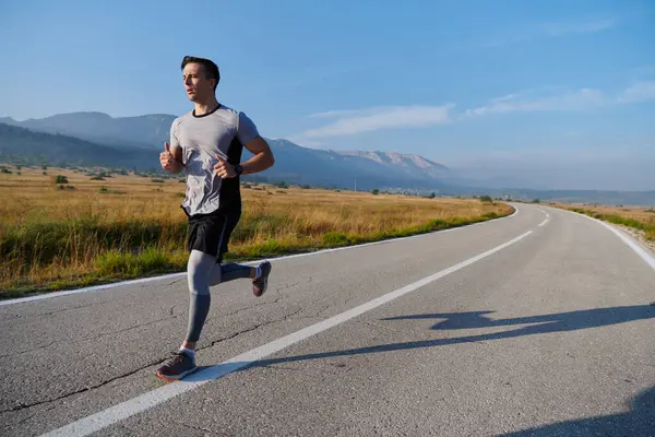 Atletik bir adam koşarken kararlılığını sergiler, sağlıklı bir yaşam tarzına ve yaklaşan maraton yarışmasına hazırlanmaya bağlıdır.