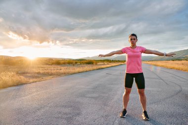 Yalnız bir sporcu, çarpıcı bir günbatımının arka planına zarifçe uzanırken yakalanır. Silueti yoğun bir koşudan sonra kendini adamışlık ve dayanıklılığın bir göstergesidir. 