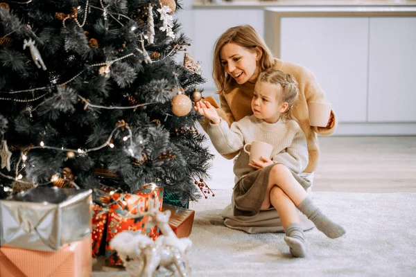 寒假和人的概念 快乐的年轻妈妈和小女儿在家里装饰圣诞树 爱与快乐 — 图库照片