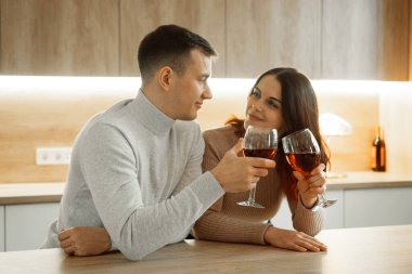 Mutlu evli adam karı koca kırmızı şarap içerek evde birlikte kutluyorlar, aile kavramı.