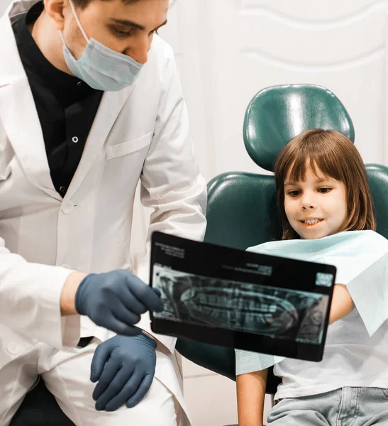 在牙科诊所 男牙医向女婴展示牙齿X光照片 口腔医学 技术和保健概念 — 图库照片