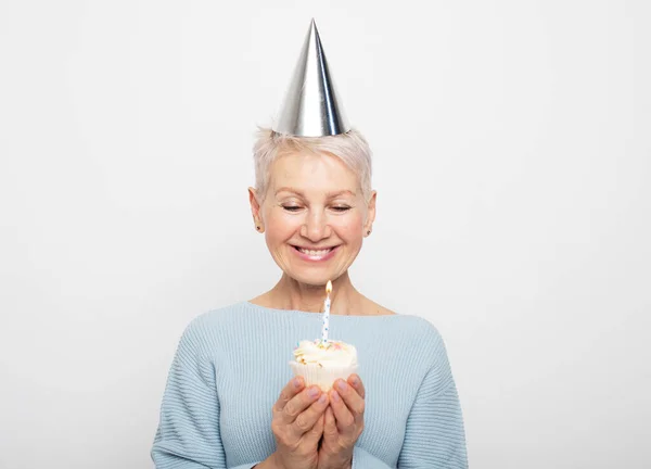 Mulher Idosa Bonita Usando Chapéu Cônico Comemorando Aniversário Com Cupcake — Fotografia de Stock