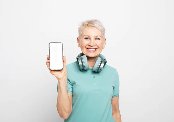 Lovely Pensioner Female Wireless Headphones Modern Senior Woman Holds Smartphone — Stock Photo, Image