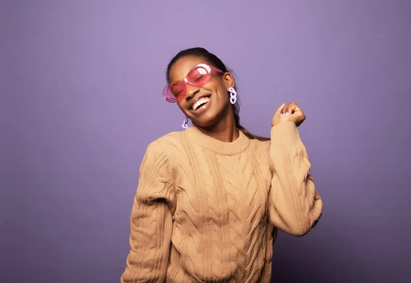 美しい若いアフロの女性の写真は ベージュのセーターを着て孤立紫色の背景を踊ります ライフスタイルと人々のコンセプト — ストック写真