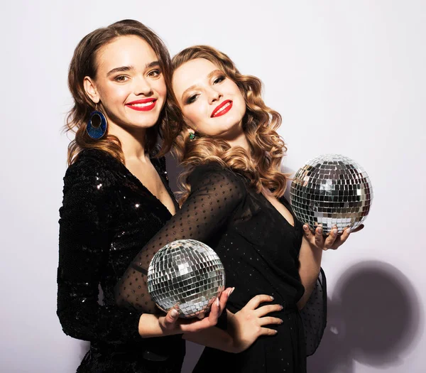 两名年轻的性感女子穿着晚礼服 在灰色背景下举行迪斯科舞会 — 图库照片