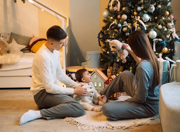 happy father standing near wife holding cute little daughter, family and christmas concept