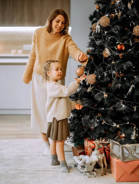寒假和人的概念 快乐的年轻妈妈和小女儿在家里装饰圣诞树 爱与快乐 — 图库照片