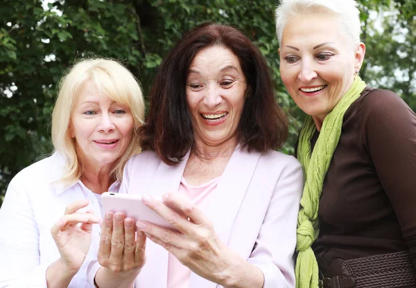 Три Пожилые Женщины Улыбаются Смотрят Фотографии Экране Телефона Парке Летний — стоковое фото