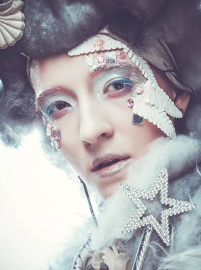 Parti, Noel ve insanlar Noel partisi kostümü ve peruğu içinde büyüleyici bir kadın. Yaratıcı makyaj, saç stili, yakın plan portre. Kış stili, Kar Kraliçesi.